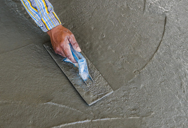 Железнение свежеуложенной бетонной стяжки сухим цементом – с некоторым упрощением это можно считать прообразом упрочнения с помощью топпинга.